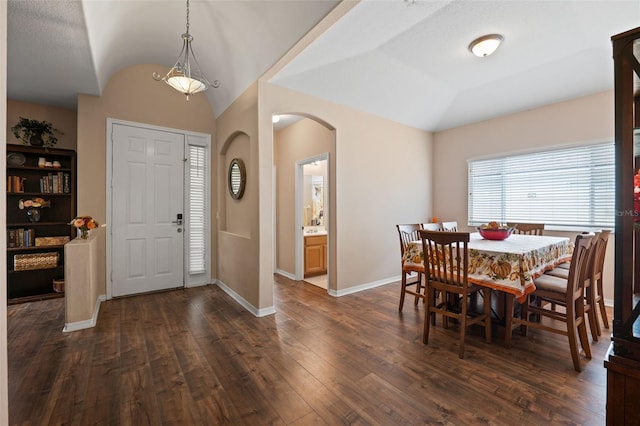 entryway featuring dark wood-type flooring, vaulted ceiling, and a textured ceiling