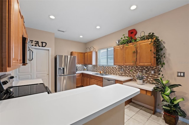 kitchen featuring sink, decorative backsplash, kitchen peninsula, and stainless steel appliances