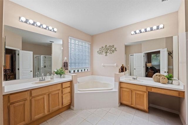 bathroom with vanity, independent shower and bath, a textured ceiling, and tile patterned flooring