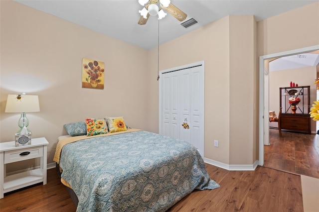 bedroom with dark wood-type flooring, ceiling fan, and a closet