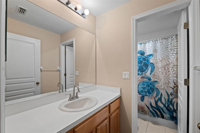 bathroom with vanity, a textured ceiling, walk in shower, and tile patterned flooring