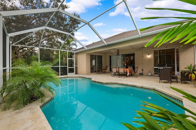 view of swimming pool featuring a patio, ceiling fan, and a lanai