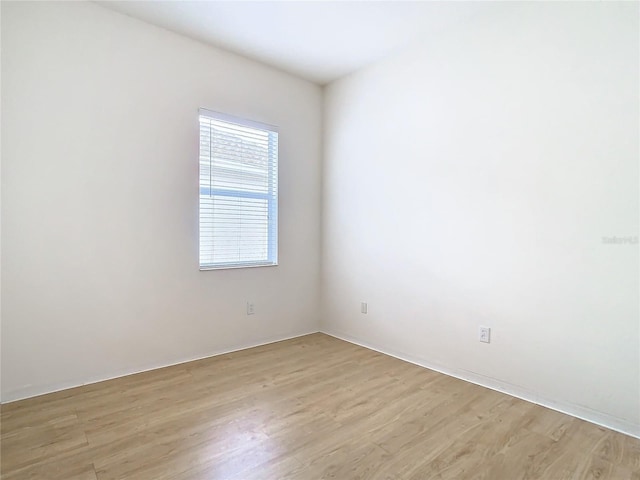 spare room featuring a wealth of natural light and light hardwood / wood-style flooring