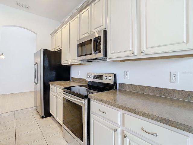 kitchen featuring light tile patterned floors, white cabinetry, and appliances with stainless steel finishes