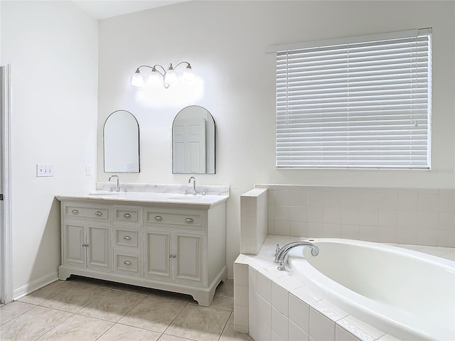 bathroom featuring vanity, tile patterned floors, and tiled bath