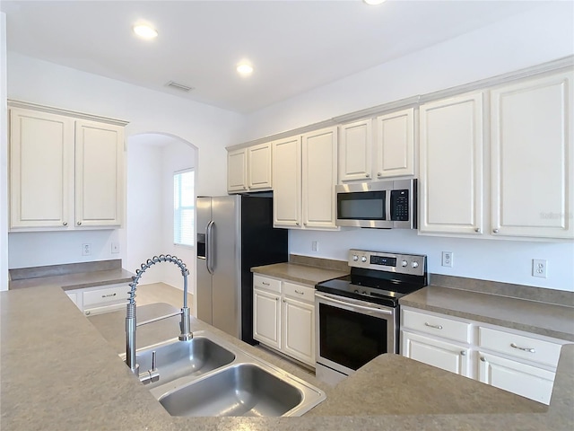 kitchen with sink, stainless steel appliances, and white cabinets