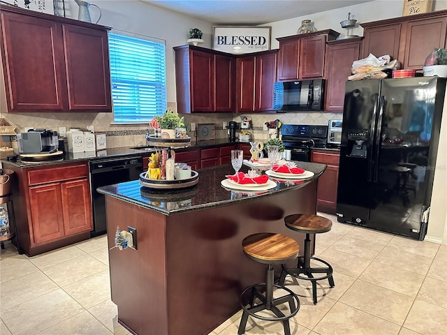 kitchen featuring black appliances, a center island, light tile patterned floors, and tasteful backsplash