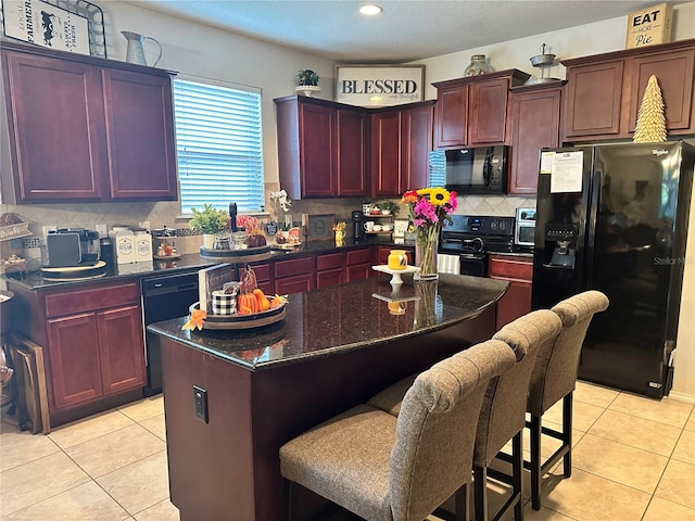 kitchen featuring decorative backsplash, black appliances, light tile patterned floors, and a kitchen island