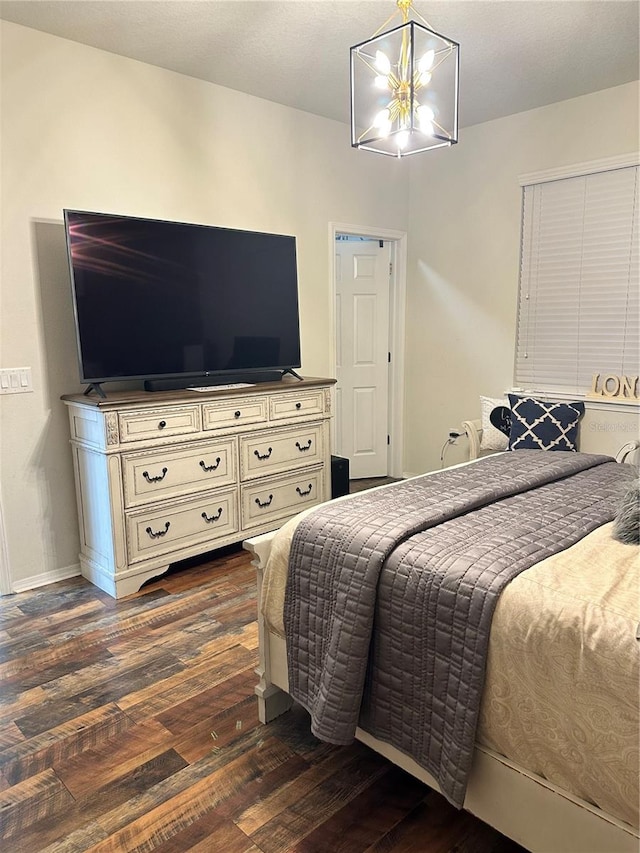 bedroom with dark wood-type flooring and a notable chandelier