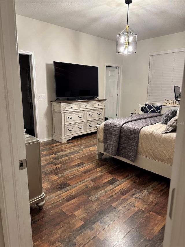 bedroom with a notable chandelier and dark hardwood / wood-style floors