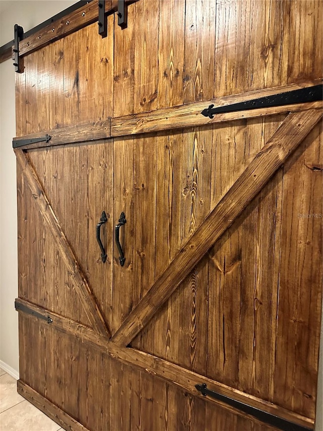 interior details featuring tile patterned floors and a barn door