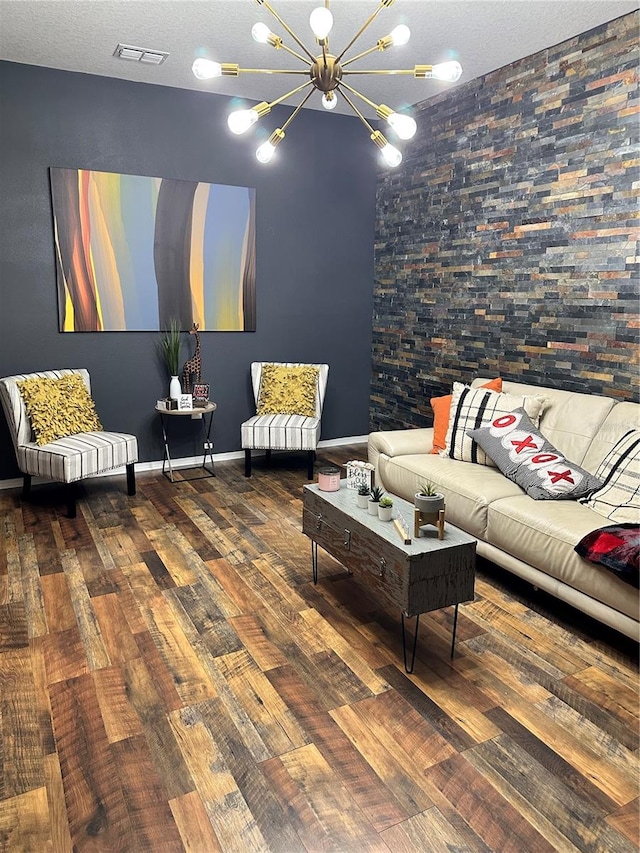 living room featuring a textured ceiling, an inviting chandelier, and dark hardwood / wood-style flooring