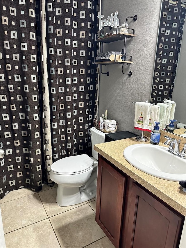 bathroom with toilet, a shower with curtain, vanity, and tile patterned floors