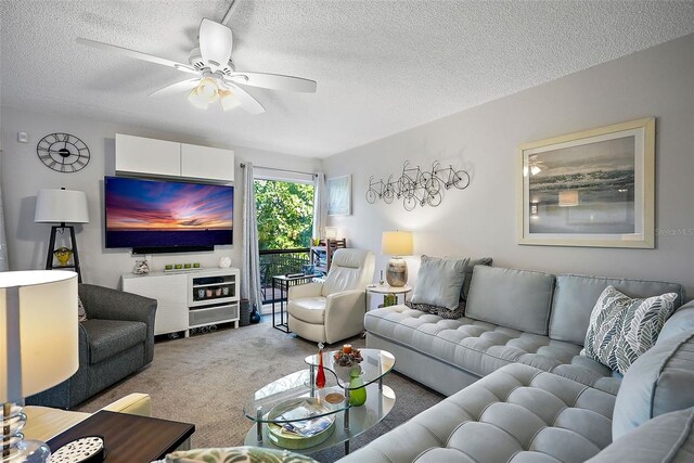 living room featuring a textured ceiling, carpet flooring, and ceiling fan