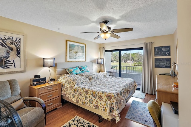 bedroom with a textured ceiling, access to outside, dark hardwood / wood-style flooring, and ceiling fan