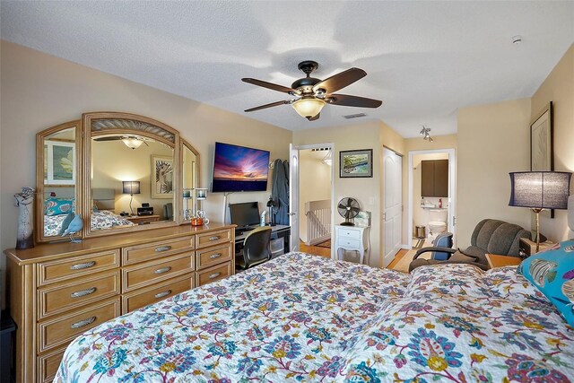 bedroom with connected bathroom, a textured ceiling, and ceiling fan