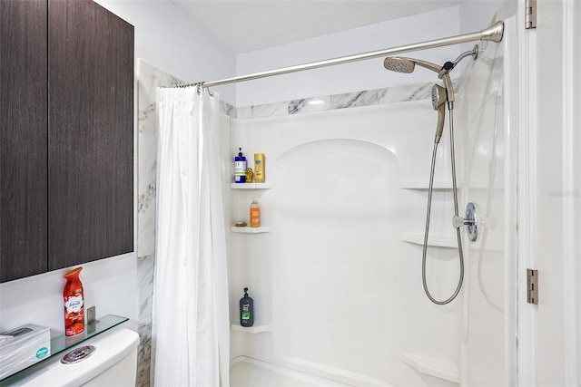 bathroom featuring toilet and a shower with curtain