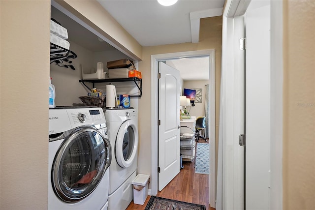 laundry room with washing machine and clothes dryer and wood-type flooring