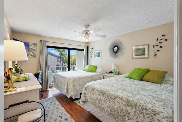 bedroom featuring access to exterior, a textured ceiling, dark wood-type flooring, and ceiling fan