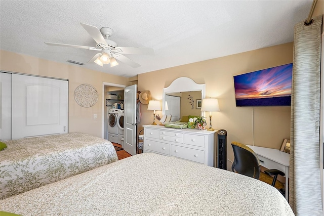 bedroom with ceiling fan, a textured ceiling, a closet, and independent washer and dryer