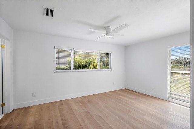 spare room featuring ceiling fan, light hardwood / wood-style floors, and a wealth of natural light