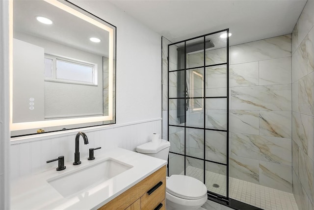 bathroom with toilet, vanity, and tiled shower