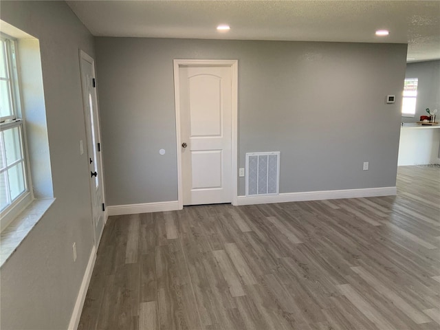 spare room with a textured ceiling and light wood-type flooring