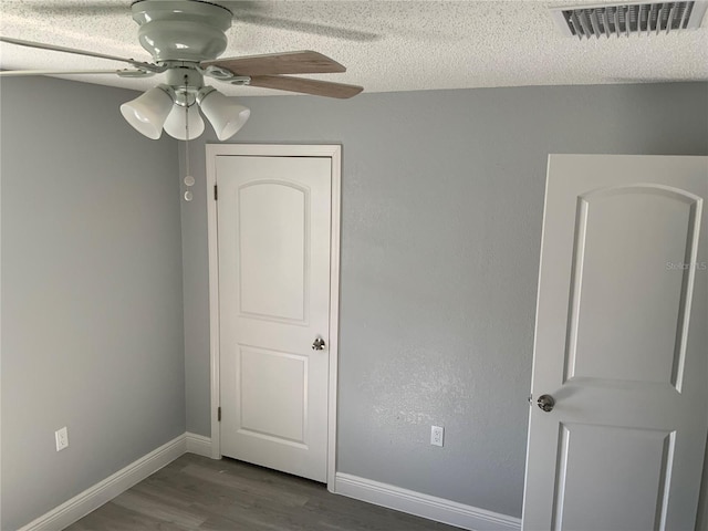 spare room featuring a textured ceiling, hardwood / wood-style flooring, and ceiling fan