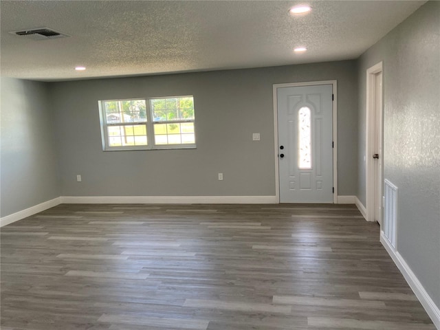 foyer entrance featuring a textured ceiling, plenty of natural light, and dark hardwood / wood-style floors