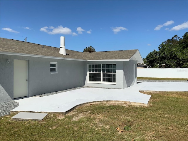 rear view of property featuring a patio area and a yard