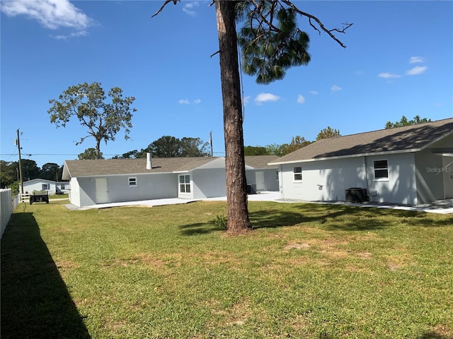 back of property with a patio area and a lawn