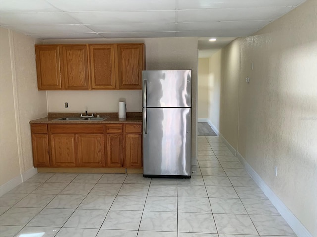 kitchen with sink, stainless steel fridge, and light tile patterned flooring