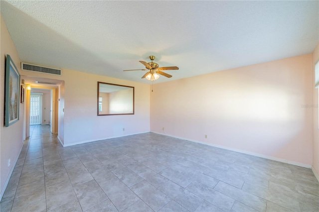 spare room featuring a textured ceiling and ceiling fan