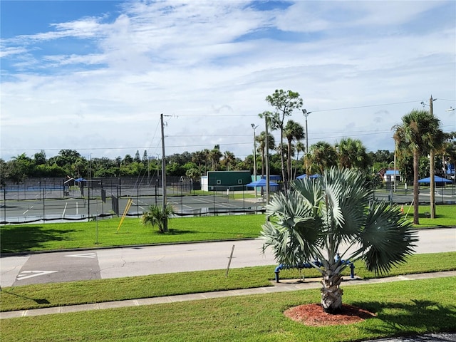 view of community with a lawn and tennis court