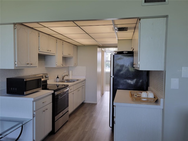 kitchen with light hardwood / wood-style floors, stainless steel appliances, sink, and white cabinets