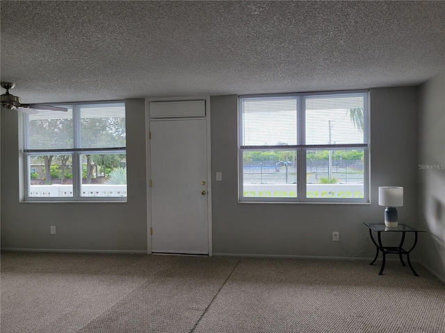 carpeted entryway with a textured ceiling and ceiling fan