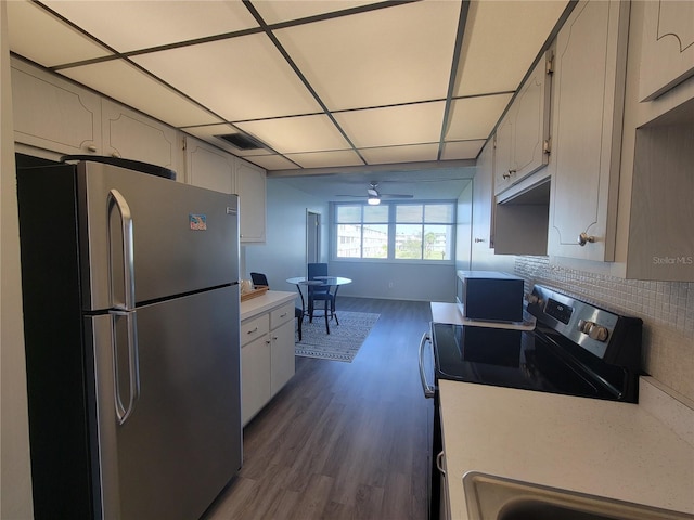 kitchen featuring backsplash, ceiling fan, stainless steel appliances, white cabinets, and dark hardwood / wood-style floors