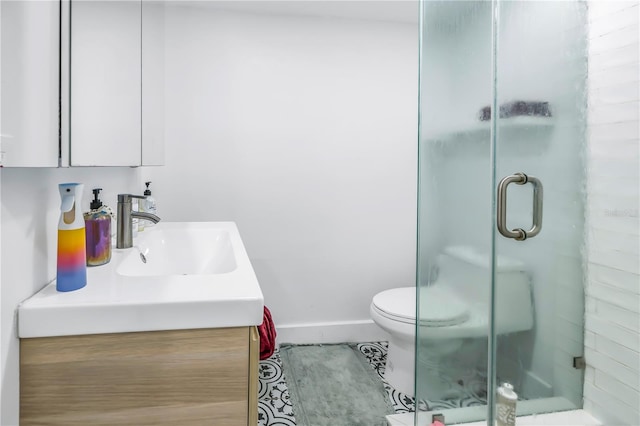 bathroom with vanity, a shower with shower door, toilet, and tile patterned floors