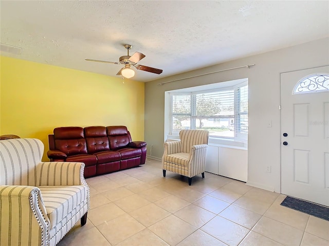 tiled living room featuring a textured ceiling and ceiling fan