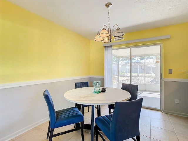 tiled dining room with a notable chandelier