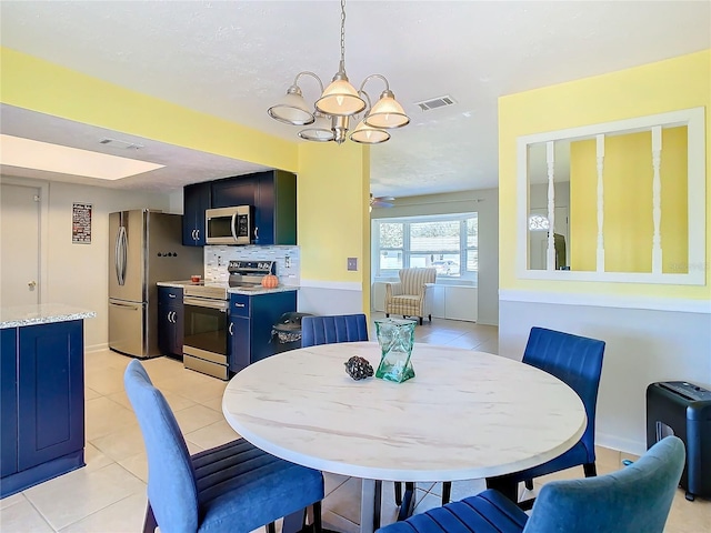 dining space with light tile patterned floors and a chandelier