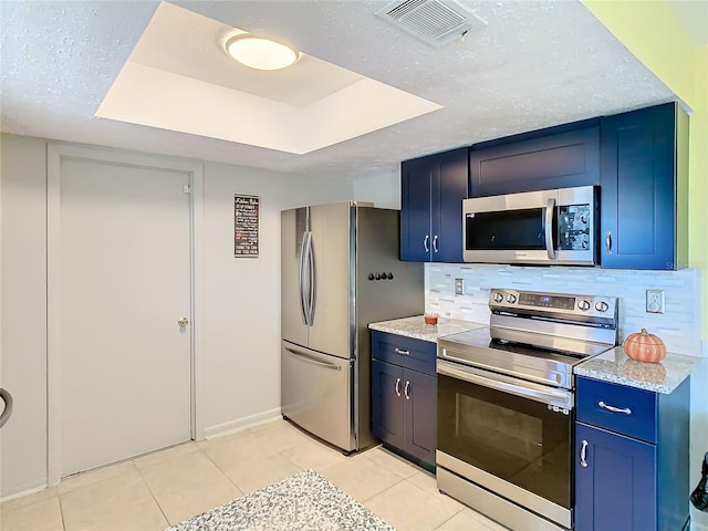 kitchen with light tile patterned flooring, blue cabinets, stainless steel appliances, and tasteful backsplash