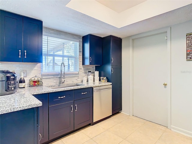 kitchen featuring stainless steel dishwasher, sink, decorative backsplash, and blue cabinetry