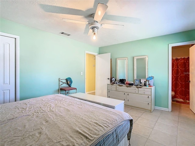 bedroom featuring ceiling fan, ensuite bathroom, and light tile patterned floors