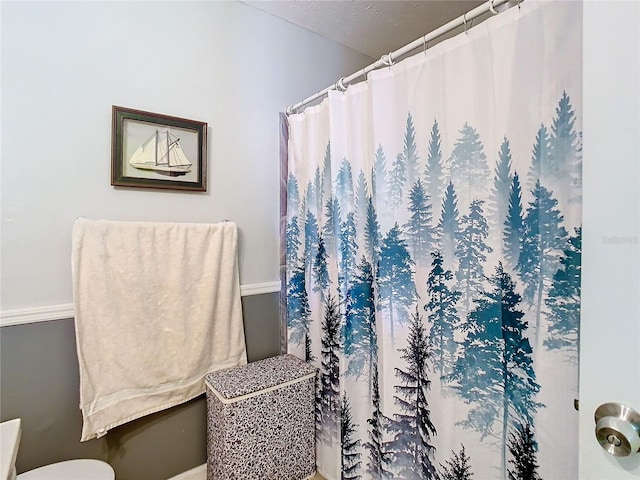 bathroom with curtained shower and toilet