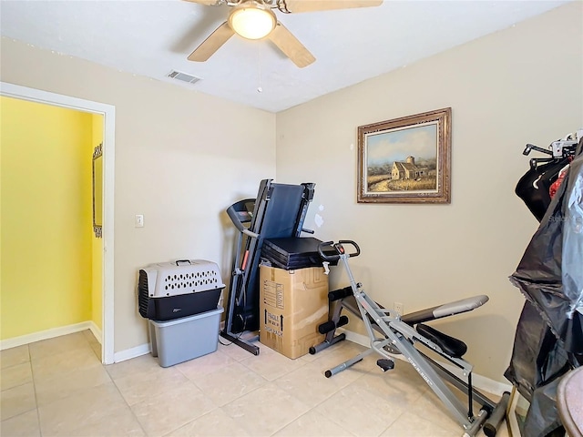 exercise area with ceiling fan and light tile patterned flooring