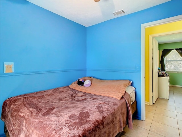 tiled bedroom featuring ceiling fan