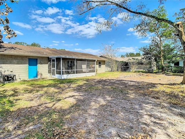 back of property with a sunroom