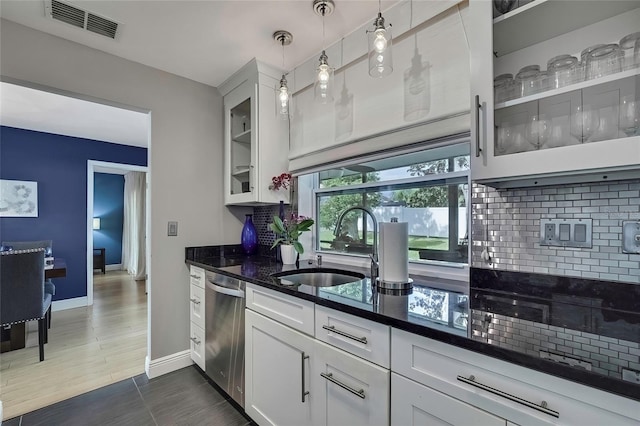 kitchen featuring white cabinetry, sink, pendant lighting, and stainless steel dishwasher