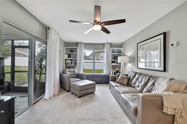 carpeted living room with ceiling fan and plenty of natural light